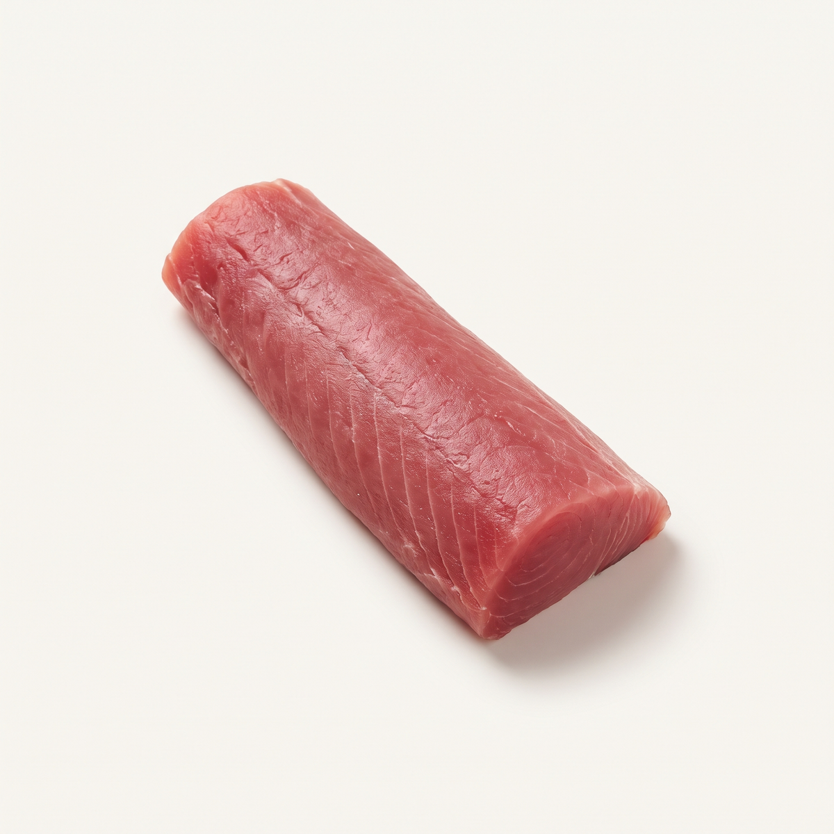 one raw skinless tuna loin, elongated deep ruby-pink solid muscle with clear fine grain, natural cut ends, no sear or garnish